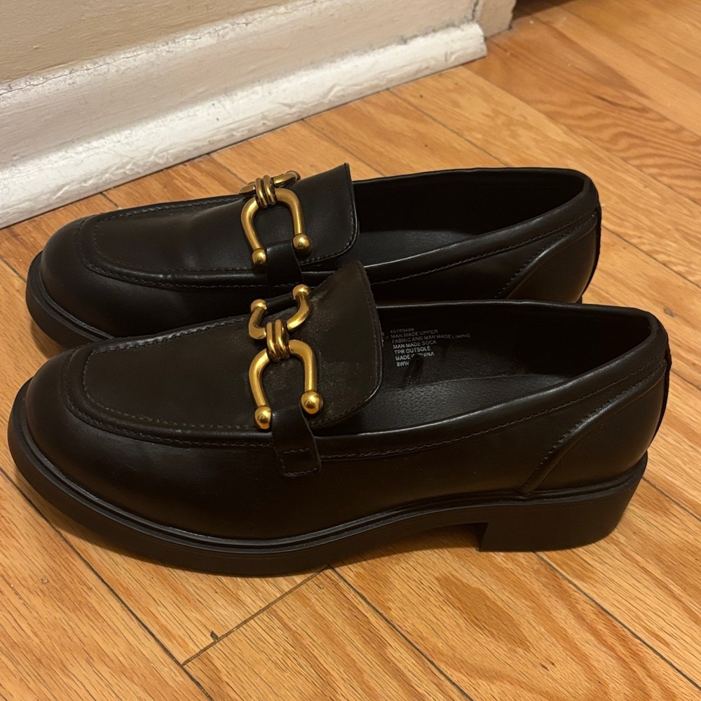 Black loafers with gold detailing